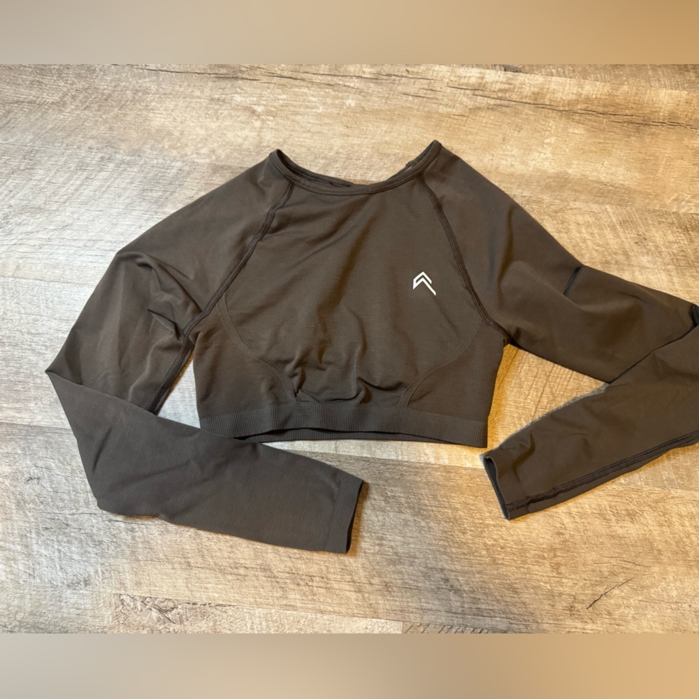 Grey long sleeve athletic crop top, open back area, no brand or size label